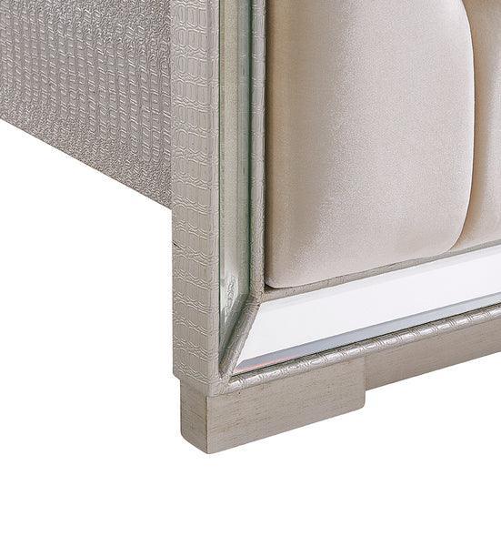 Close view of silver fabric upholstered bed frame with textured panel and mirrored trim