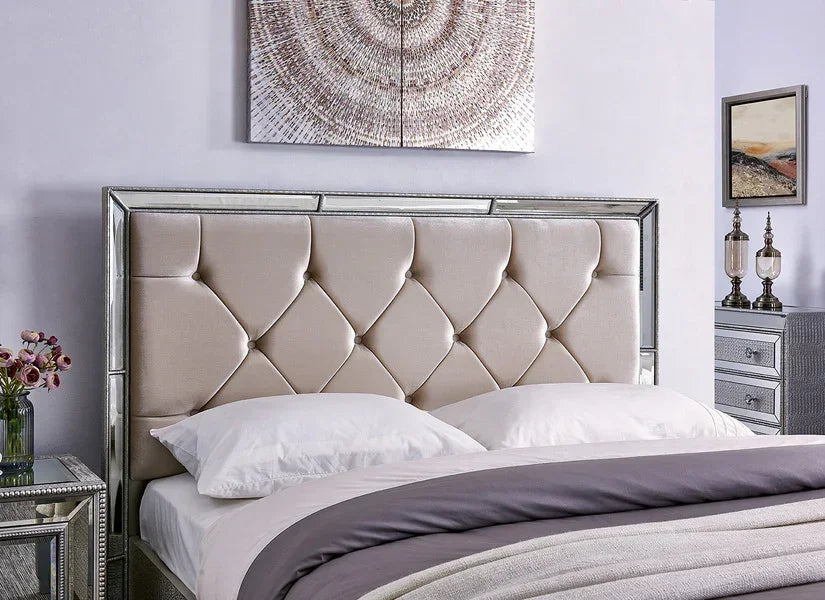 Tufted upholstered bed with mirrored frame, white bedding, and decorative bedside tables