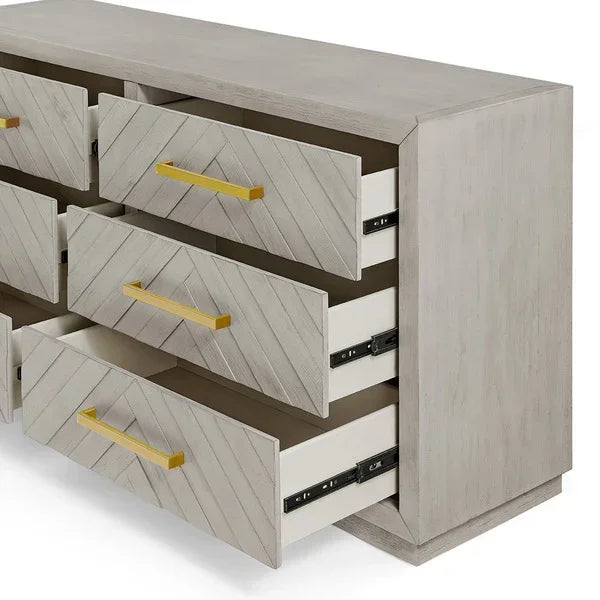 Light wood chest of drawers with chevron fronts and gold handles, drawers open