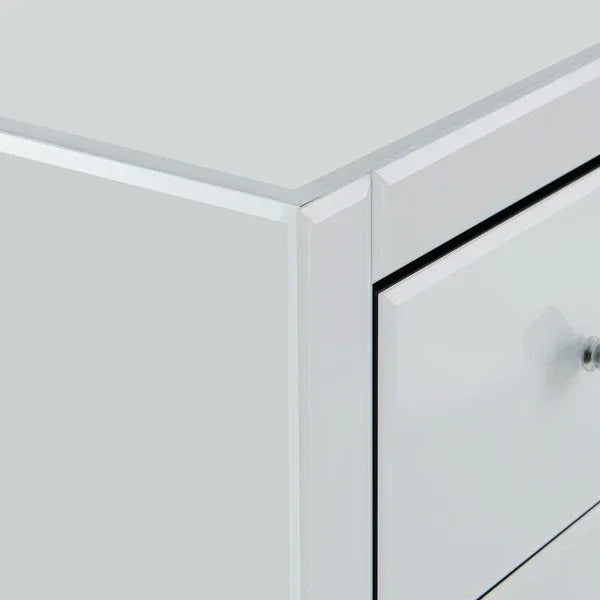 Close-up of mirrored bedside table corner with drawer and crystal knob