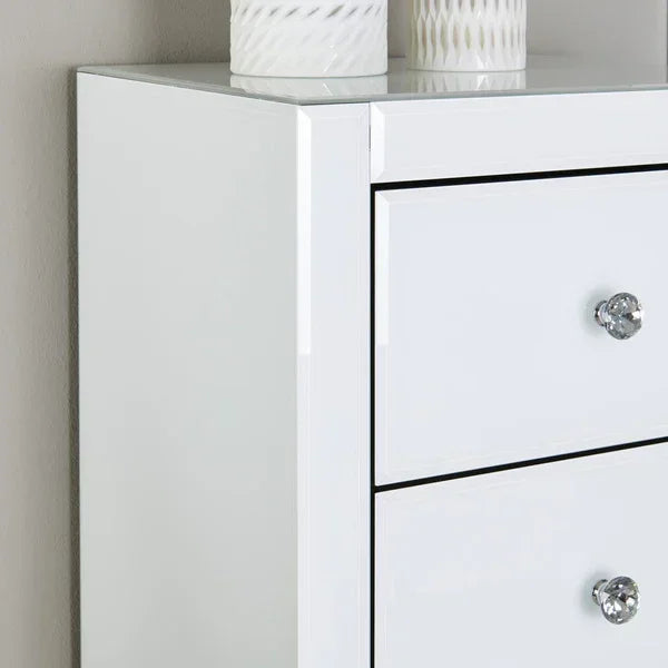 White gloss chest of drawers with crystal handles and decorative vases on top