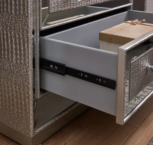Silver textured bedside table drawer open on wooden floor with storage box inside