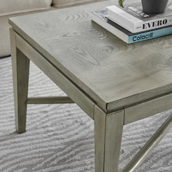 Light wood coffee table with books and decor on textured rug