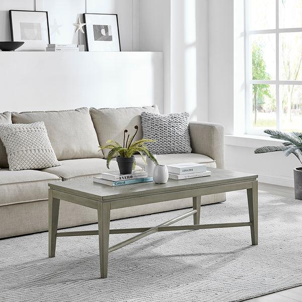 Light wood coffee table in front of beige fabric sofa with textured cushions