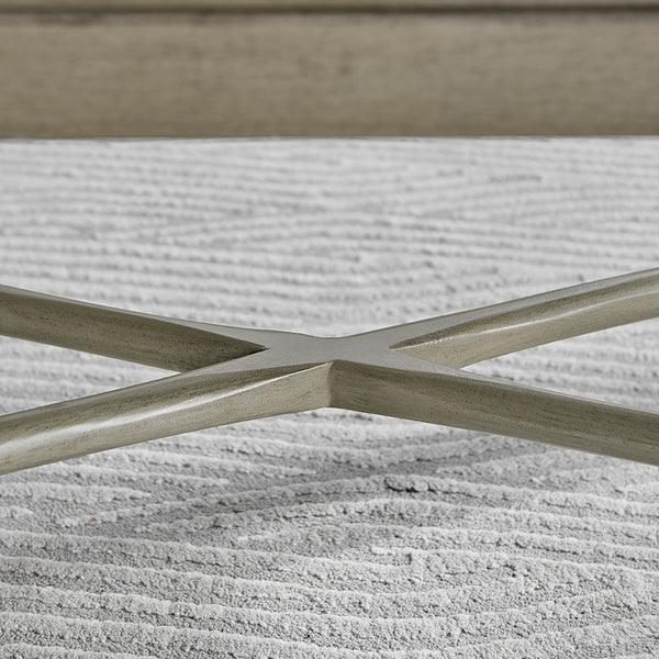 metal coffee table base with crossed legs on textured grey rug