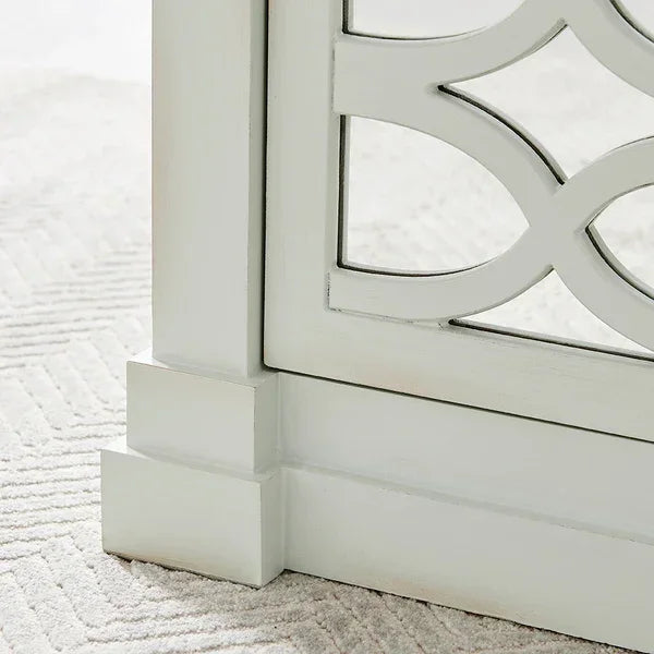 White wooden furniture leg with decorative lattice detail on neutral carpet