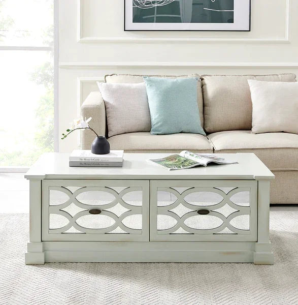 White mirrored coffee table with geometric design in front of beige sofa in living room