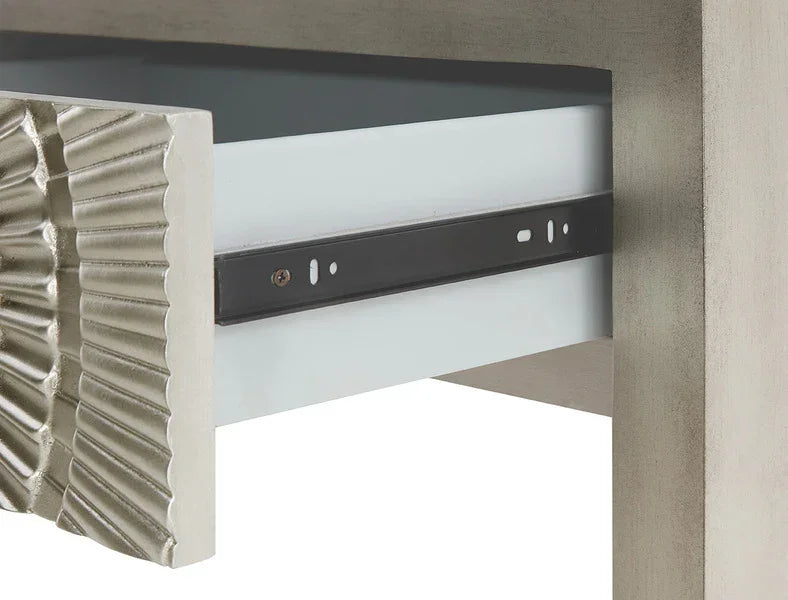 Closeup of metallic drawer slide on a modern furniture piece with textured silver detail