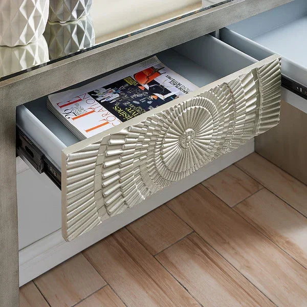 Textured silver console table with glass top, open drawer and magazines inside