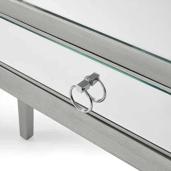 Mirrored drawer front with chrome ring handle on silver console table