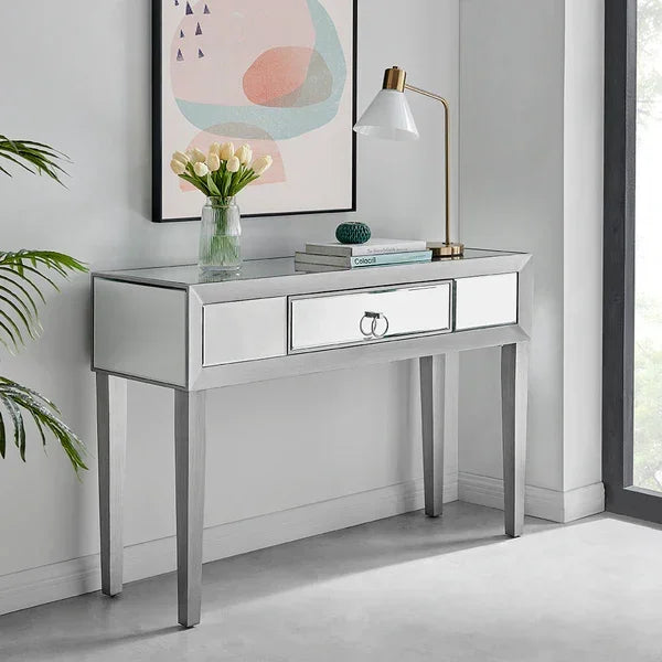 Mirrored console table with drawers in modern hallway, styled with lamp, books and vase
