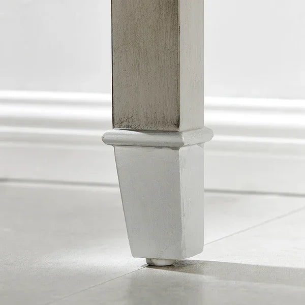 Close-up of painted wooden furniture leg on tiled floor