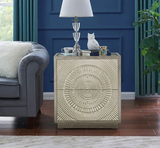 Silver metallic cabinet with geometric embossed pattern beside grey sofa in living room