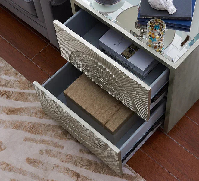 Mirrored bedside table with open drawers displaying geometric patterns and storage boxes