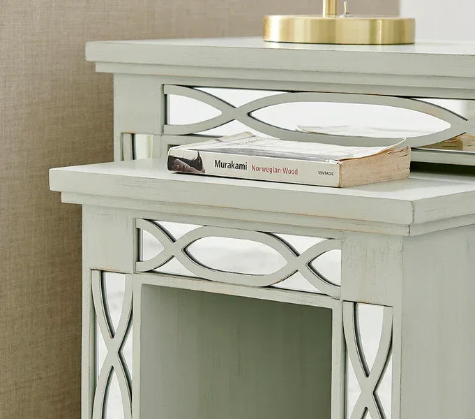 Light wood bedside table with mirrored lattice detail and book on top