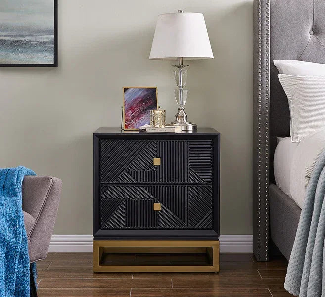 Modern black bedside table with gold base, two drawers, and geometric textured front