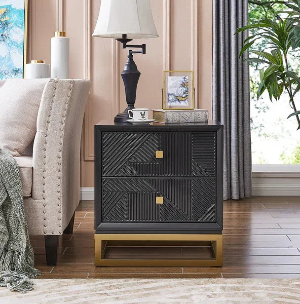 Black geometric bedside table with gold base and two drawers beside beige sofa in living room