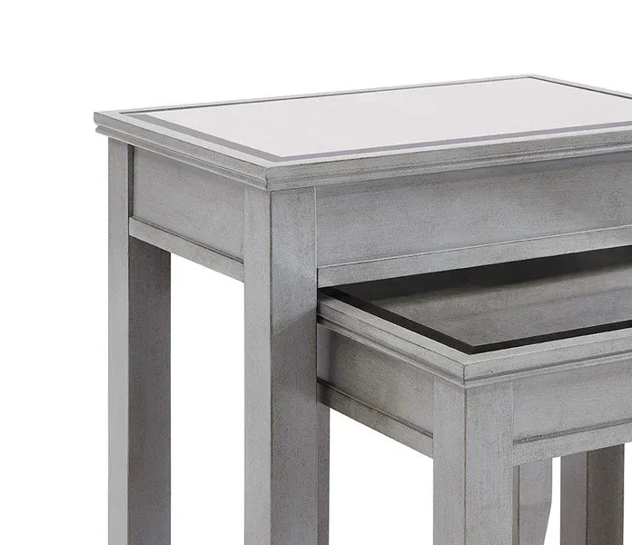 Grey wood nesting tables with glass top, partial close-up side view