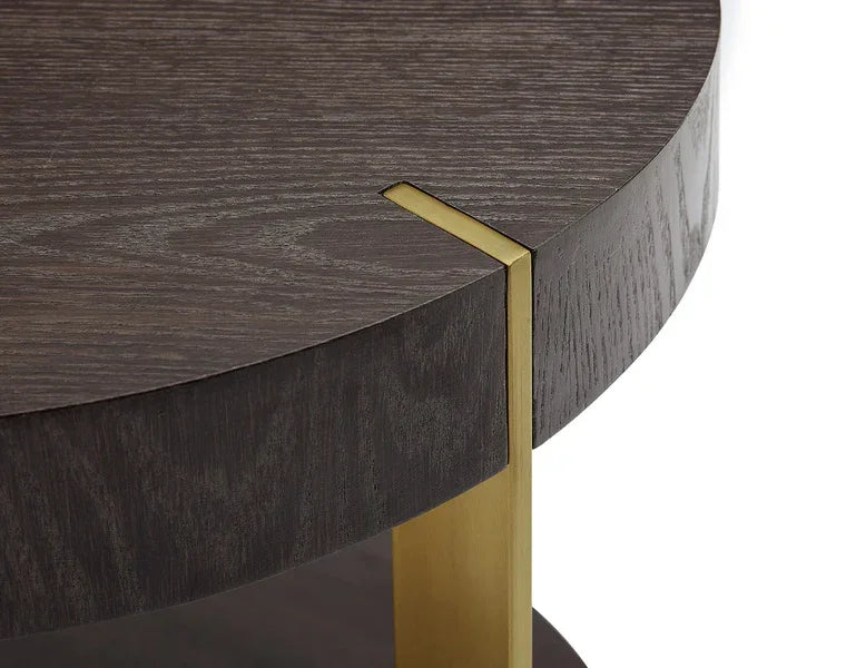 Close up of round dark wood coffee table with gold metal leg detail