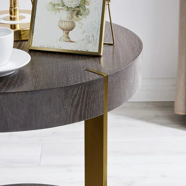Round wooden side table with gold metal legs, cup and saucer, framed floral artwork