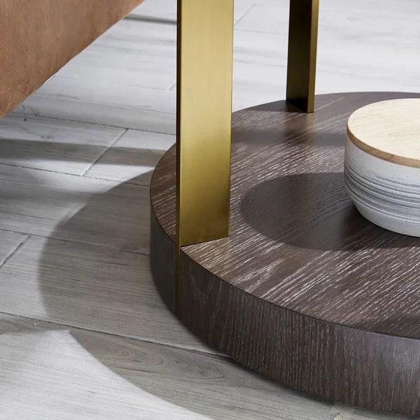 Round wood coffee table base with gold metal legs on grey tile floor