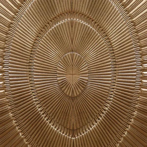 Close up of gold metal wall art with radial textured pattern