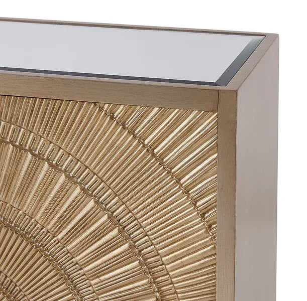 Gold embossed console table with sunburst pattern and glass top corner view