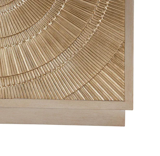 Wooden chest of drawers corner with textured carved sunburst detail in light oak finish