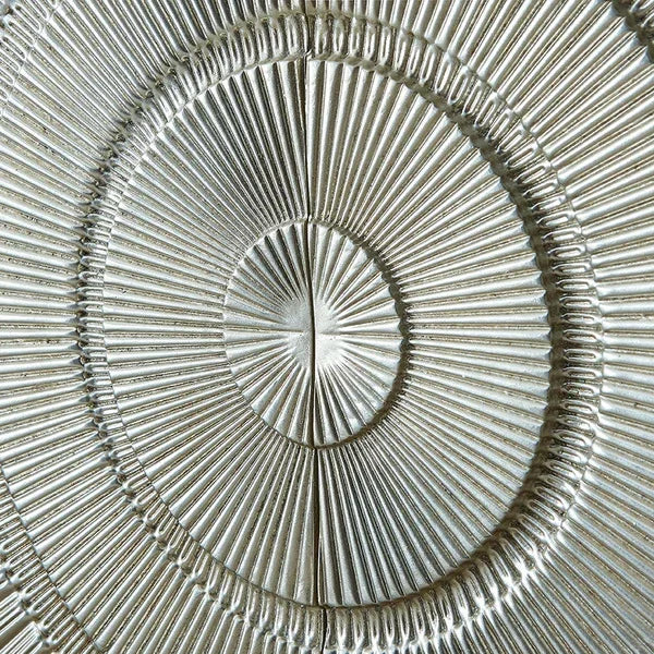 Closeup of metallic wall decor with embossed concentric circle pattern