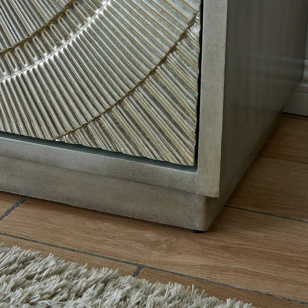 Textured wood bedside table with metallic accent and carved geometric drawer front