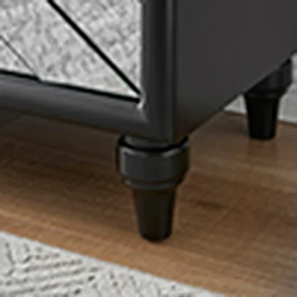 Black wooden sofa leg detail on wooden floor and patterned rug