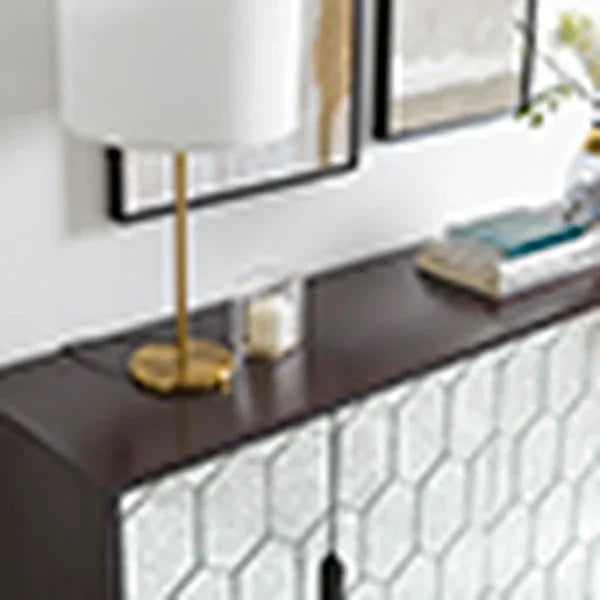Modern sideboard with honeycomb front, gold table lamp and books on dark wood surface