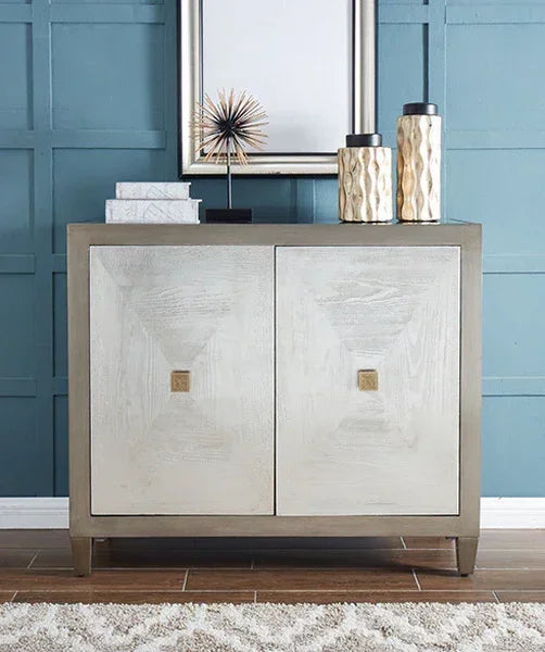 Two-door wooden sideboard cabinet with decorative vases and books, against blue wall panel