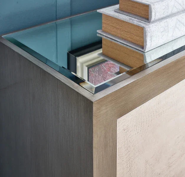 Modern mirrored bedside table with stacked books on top