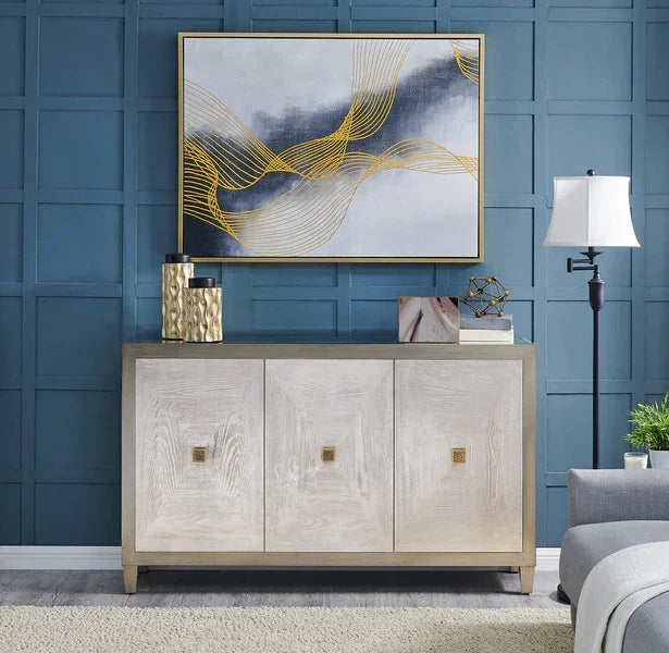 Light wood sideboard with three doors, gold decor accents, modern art on blue paneled wall