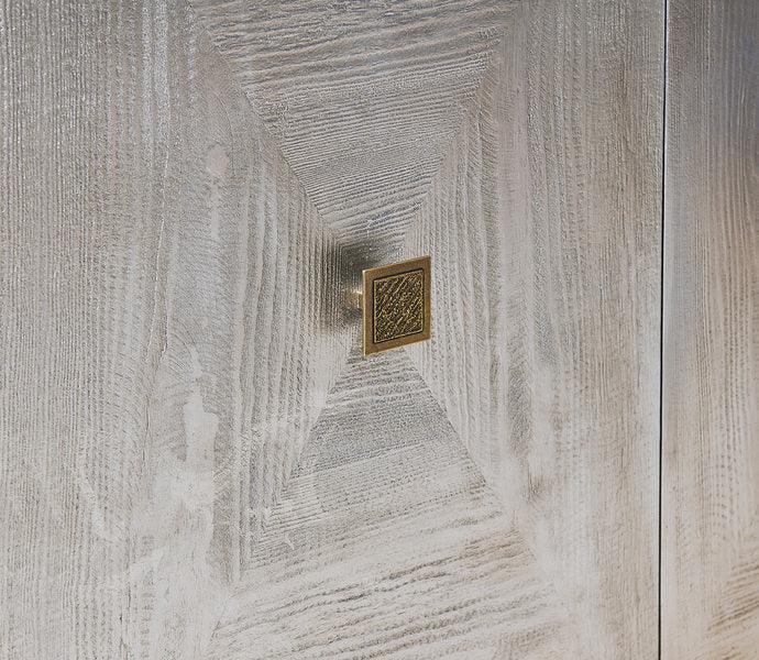 Textured wood cabinet door with square brass handle, light oak finish, front view