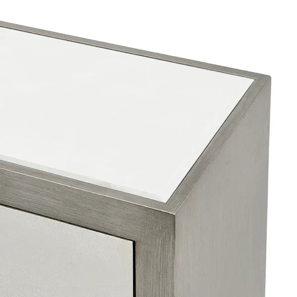 Close up of modern bedside table with brushed metal frame and white glass top