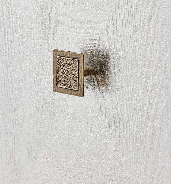 Square brass cabinet handle on textured white wood furniture surface