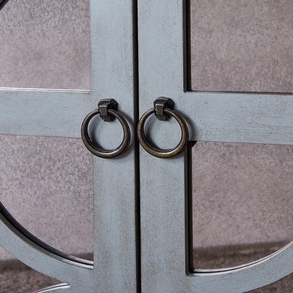 Close up of metal cabinet door handles with circular ring pulls on grey cabinet