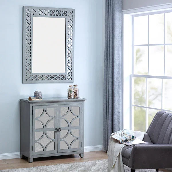 Grey mirrored cabinet with geometric doors beside window and matching mirror above