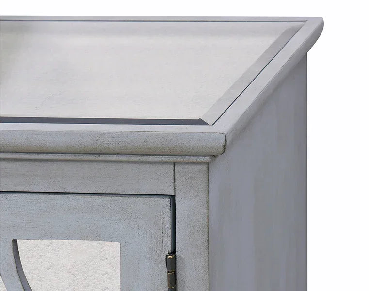 Close view of painted wood cabinet corner showing beveled top and panel door