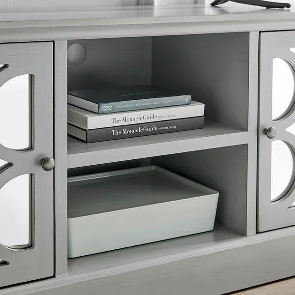 Grey wooden TV unit with mirrored cabinet doors and open shelving for books and decor