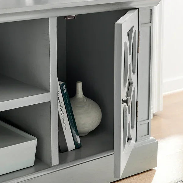 Grey wood sideboard cabinet with open shelf, books, and vase on lower compartment