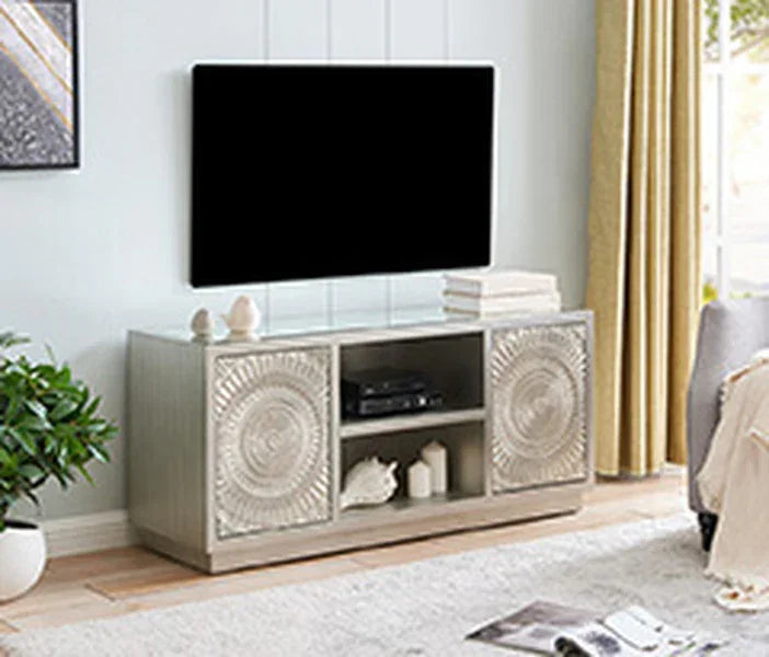 Wooden TV stand with carved cabinet doors, open shelves and decorative items in living room