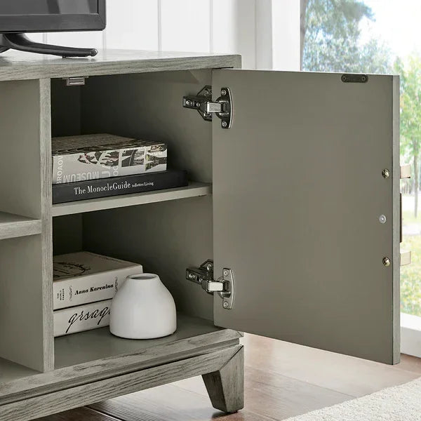 Grey wood TV unit with open storage cabinet, shelves holding books and a small white vase