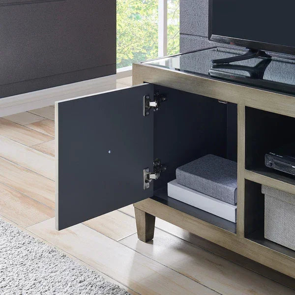 Wooden TV unit with glass top, open cabinet door, shelves storing books and boxes