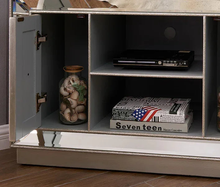 Mirrored TV unit shelf with decorative jar, magazines, and media player on wood floor