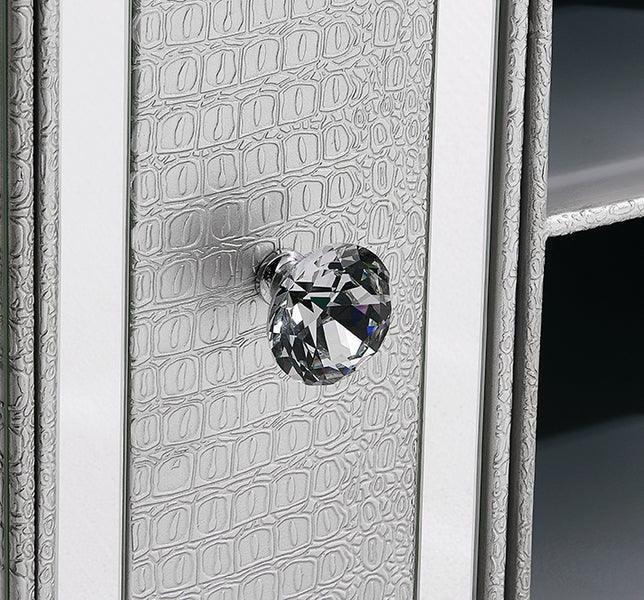 Close-up of mirrored furniture drawer with crystal handle and textured silver finish