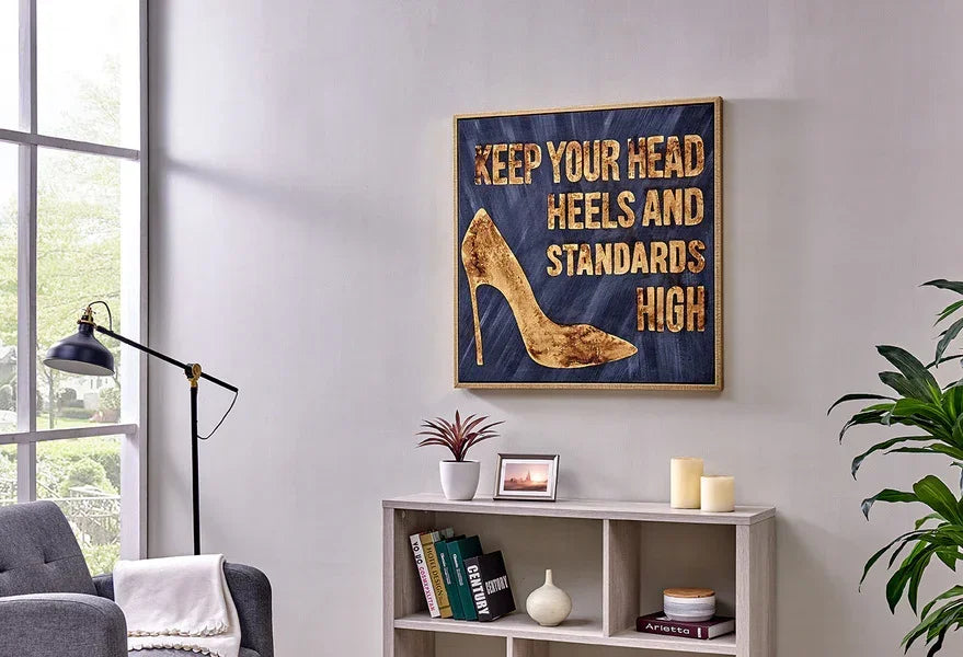 Modern living room with grey armchair, bookshelf, and gold quote wall art décor
