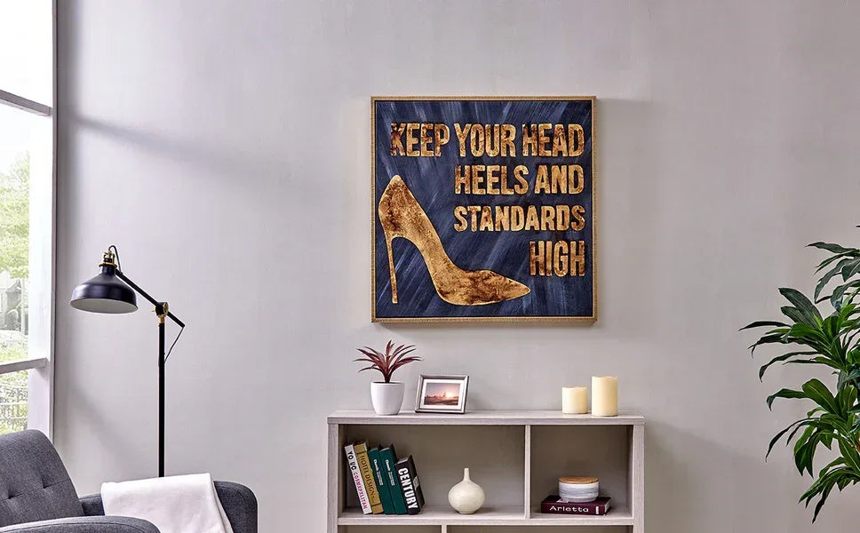 Modern living room with grey sofa, bookshelf, and shoe art wall decor above